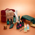 Achieve a salon-quality manicure at home with the Manucurist Green Flash™ Ultimate Kit Gift Set, which includes premium nail polishes, remover, filing tools, essential nail accessories, mini bottles, a stylish dark green LED nail lamp for perfect results, and an elegant red carrying case—all beautifully arranged on a bronze-toned surface.