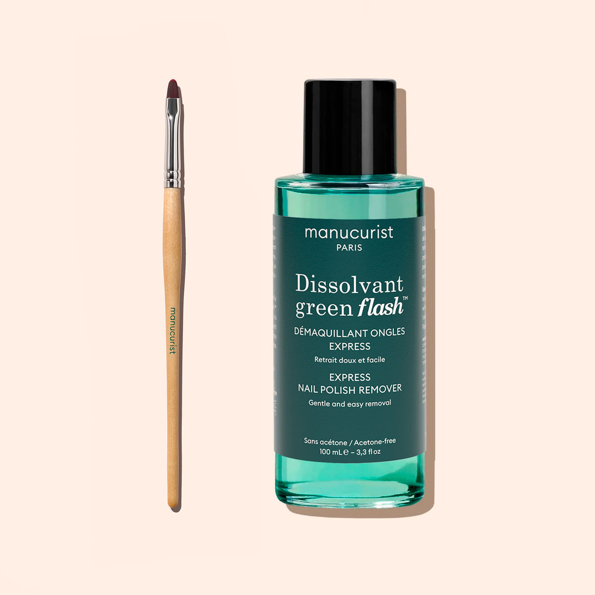 Une bouteille de dissolvant pour vernis à ongles Manucurist Green Flash est posée à côté du Flat Brush Manucurist, un pinceau fin à pointe avec un manche en bois — le tout disposé sur un fond beige clair, idéal pour une manucure précise et le soin des cuticules.