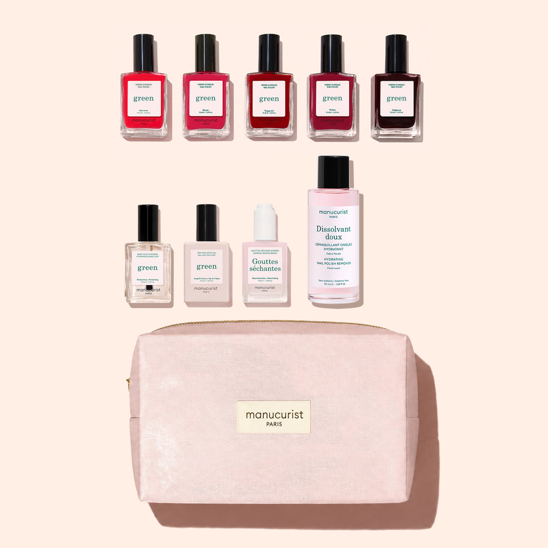 Nine manicure products from Manucurist’s Super Starter Kit—including seven bottles of plant-based nail polish, one remover, and one drops—are arranged above a pink zippered makeup bag labeled “manucurist PARIS” on a light pink background.