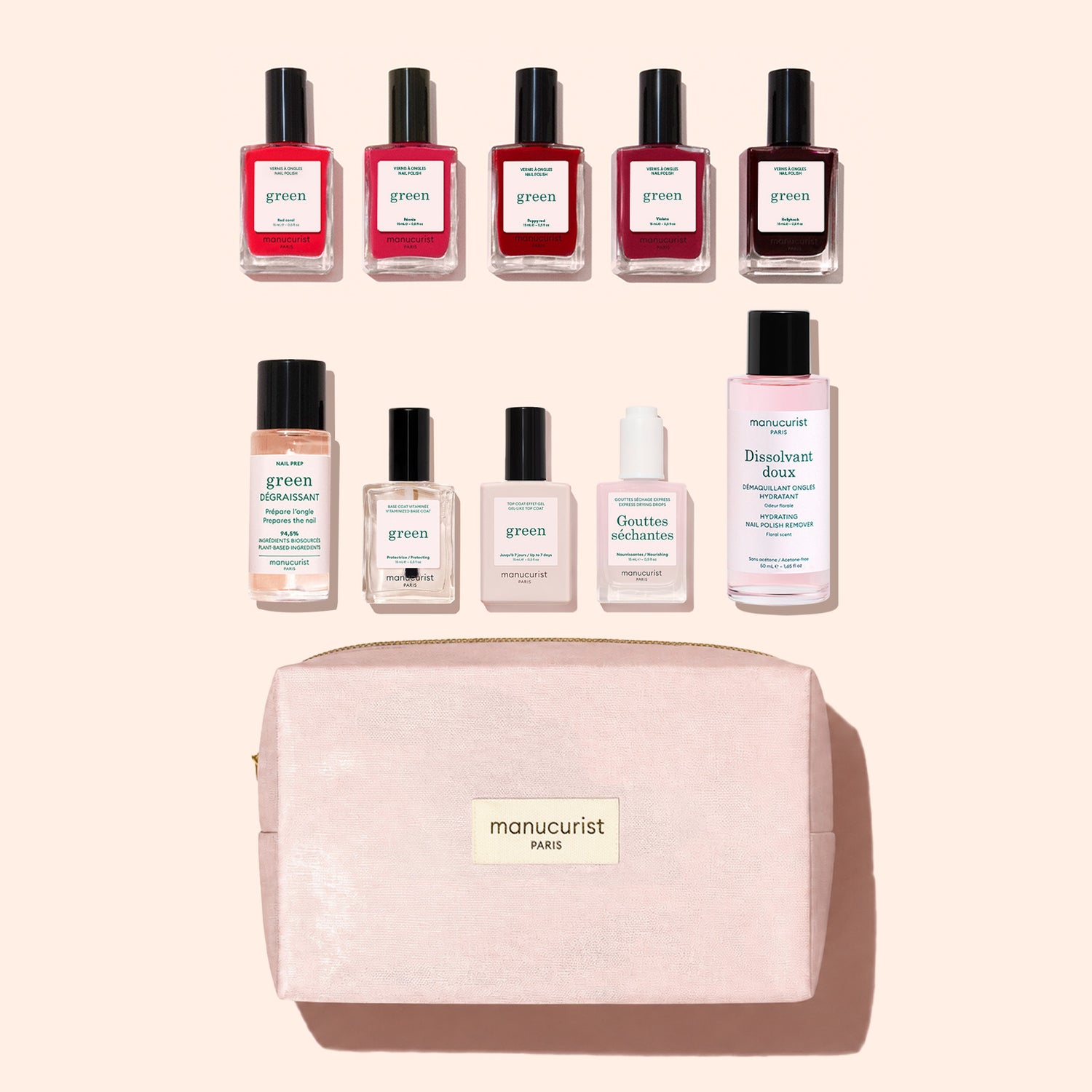 Nine bottles of Manucurist plant-based nail polish and a pink bottle of nail polish remover are arranged above a light pink zippered pouch labeled “manucurist PARIS” from the Super Starter Kit, all set against a light background.