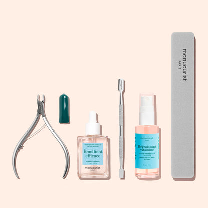 Manucurist Cuticle Clippers manicure set including stainless steel clippers, a small cap, a bottle of cuticle remover, a metal pusher, a spray bottle of nail prep lotion, and a nail file.