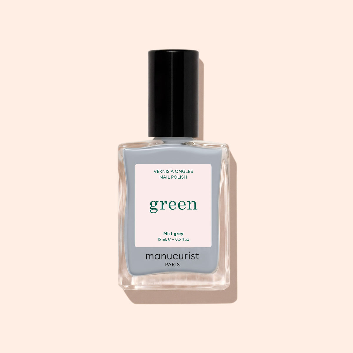 A 15 mL (0.5 fl oz) bottle of Manucurist Mist Grey nail polish from the Green™ range, featuring a black cap and &