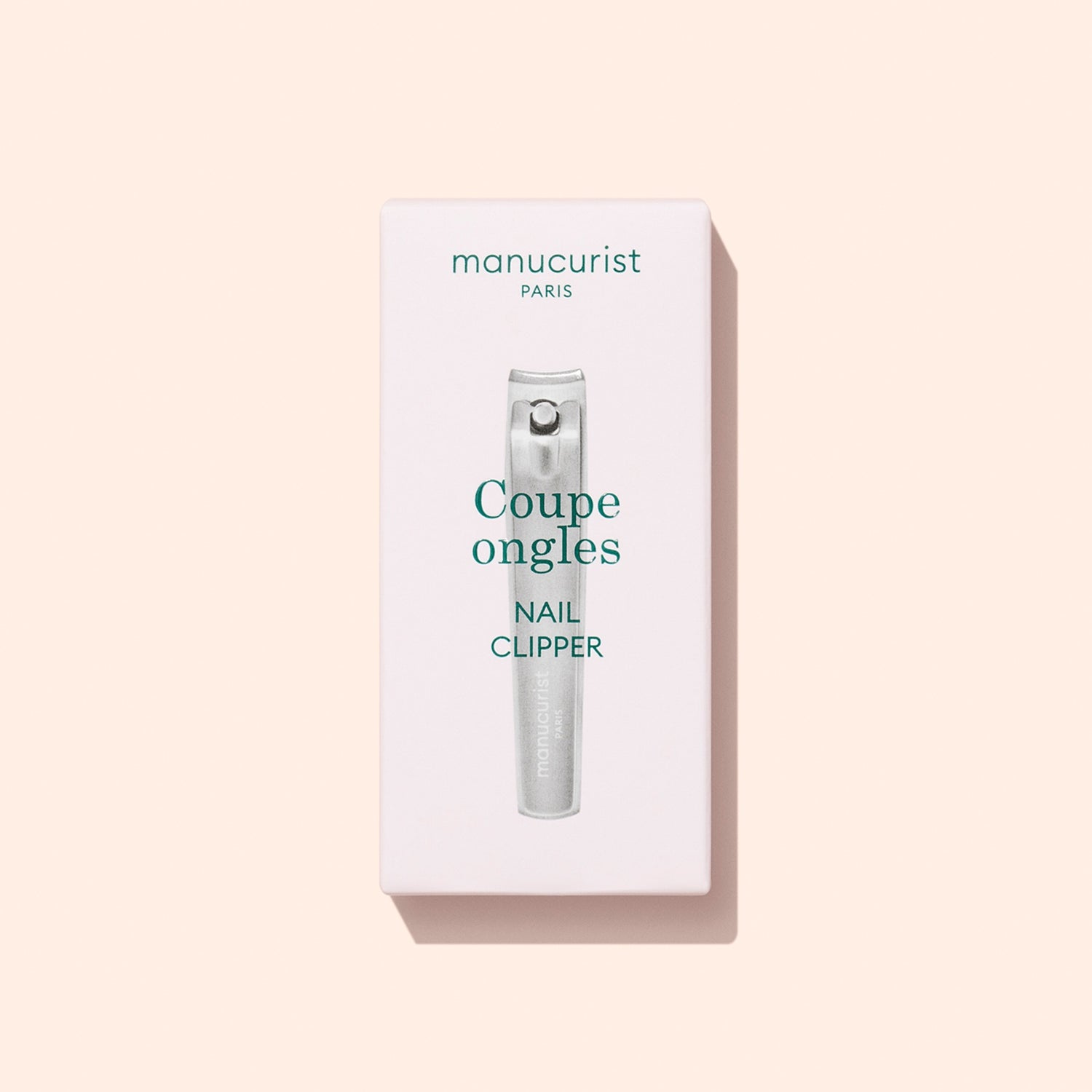 A box of Manucurist Nail Clipper, a precision nail cutter and must-have manicure tool, featuring the text “Coupe ongles Nail Clipper” on a light pink background.