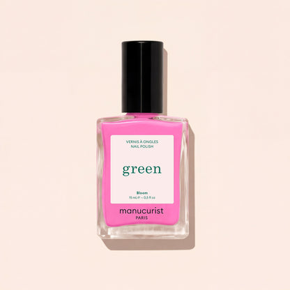 A 15 mL Manucurist Bloom neon pink nail polish with blue undertones and a black cap. The label says “green,” “Bloom,” and “15 mL – 0.5 fl oz.” The bottle casts a shadow on a light background.