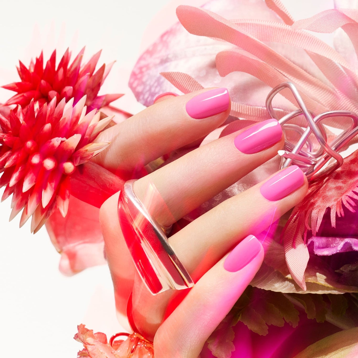 A vibrant close-up shows a hand with Manucurist&