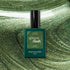 A bottle of Manucurist Groove Green Flash gel polish rests on a swirling, shimmering green background that matches the bold metallic green shade of this striking Manucurist color.