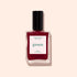 A bottle of Manucurist Amour nail polish—a luminous burgundy shade from their Green™ collection—featuring a black cap and a white label printed with “green” and “Paris,” displayed on a pale beige background.