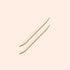 Two Manucurist US Wooden cuticle sticks (x2), each featuring pointed and angled ends, are placed parallel to each other on a pale beige background.