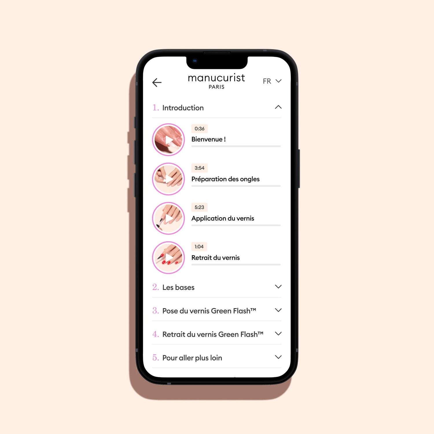 A smartphone with a black frame on a beige background runs Manucurist-test’s Training videos app, showing icons and timed steps—introduction, nail prep, polish application, and removal—in a step-by-step French manicure video tutorial.