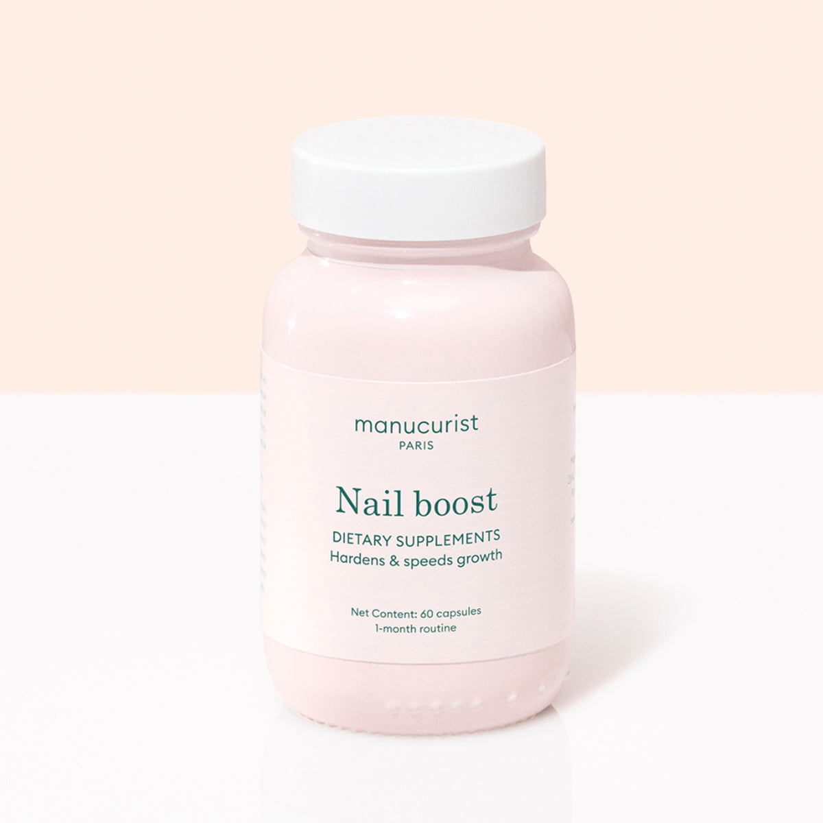 Un flacon rose étiqueté Manucurist Nail Boost contenant 60 gélules de compléments alimentaires pour les ongles pour une cure d&