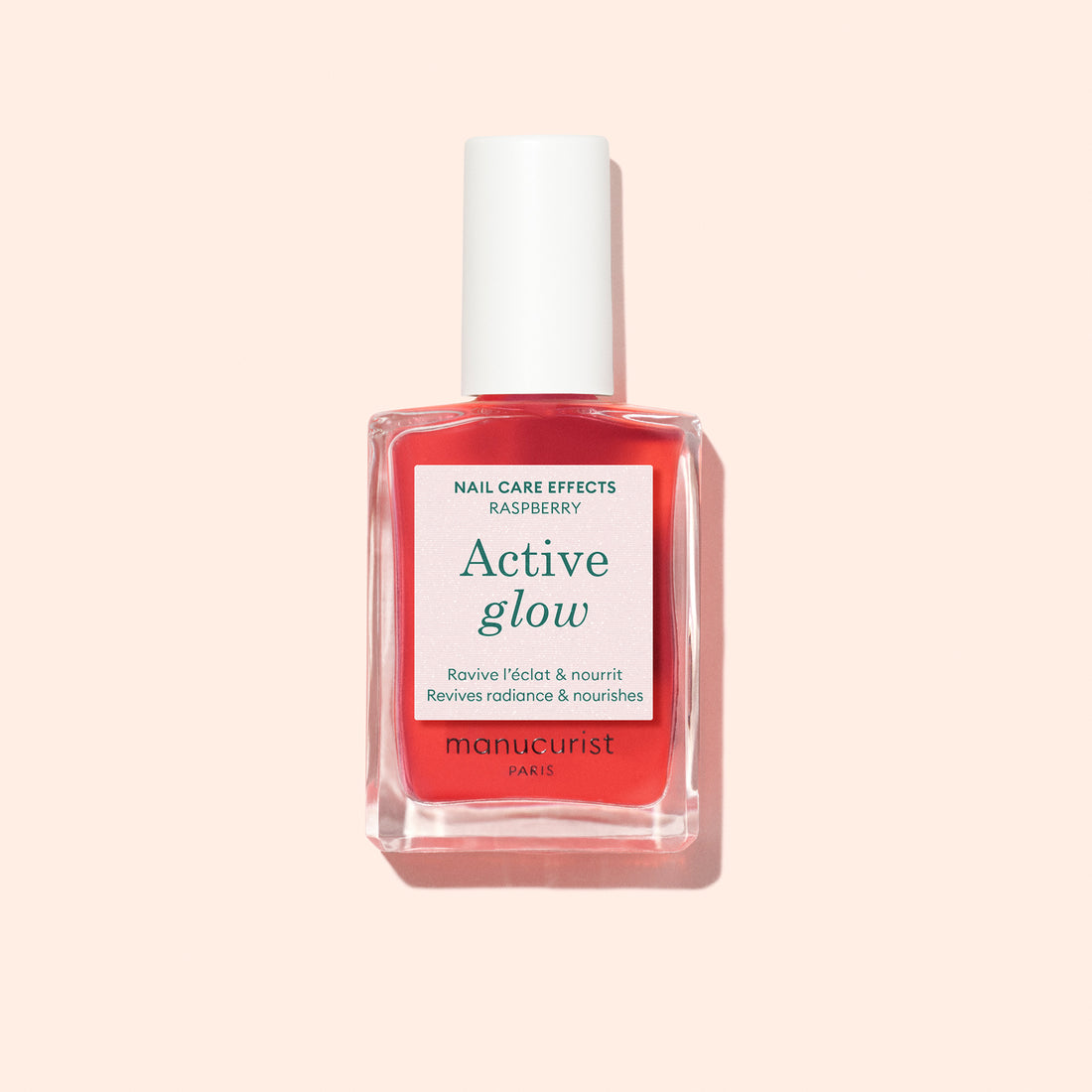 Manucurist Active Glow Raspberry, a plant-based nail enhancer, is displayed in a clear bottle with a white cap and pink label, set against a pale pink background.