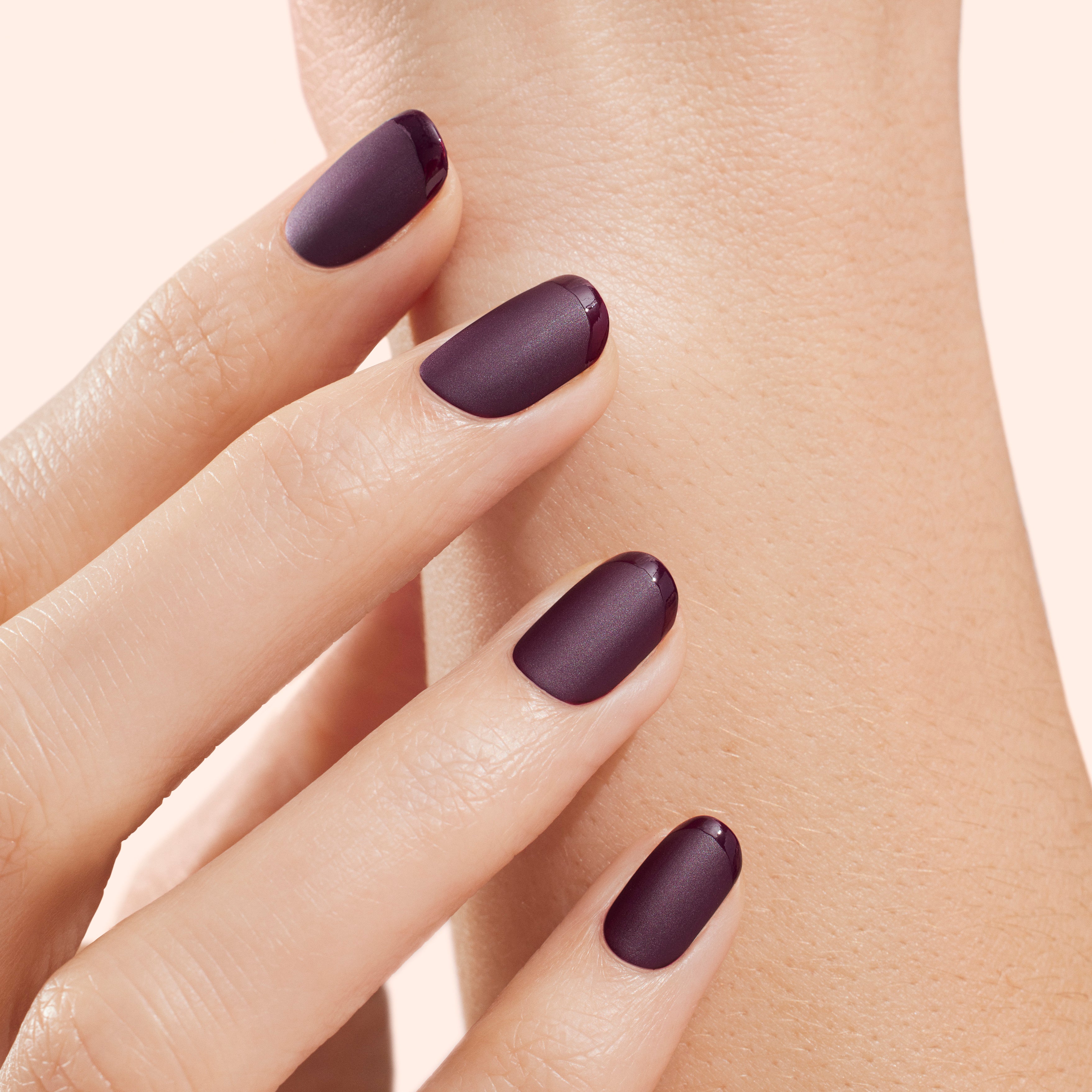 Female hand with long nails and dark purple lilac manicure holds a bottle  of nail polish Stock Photo - Alamy