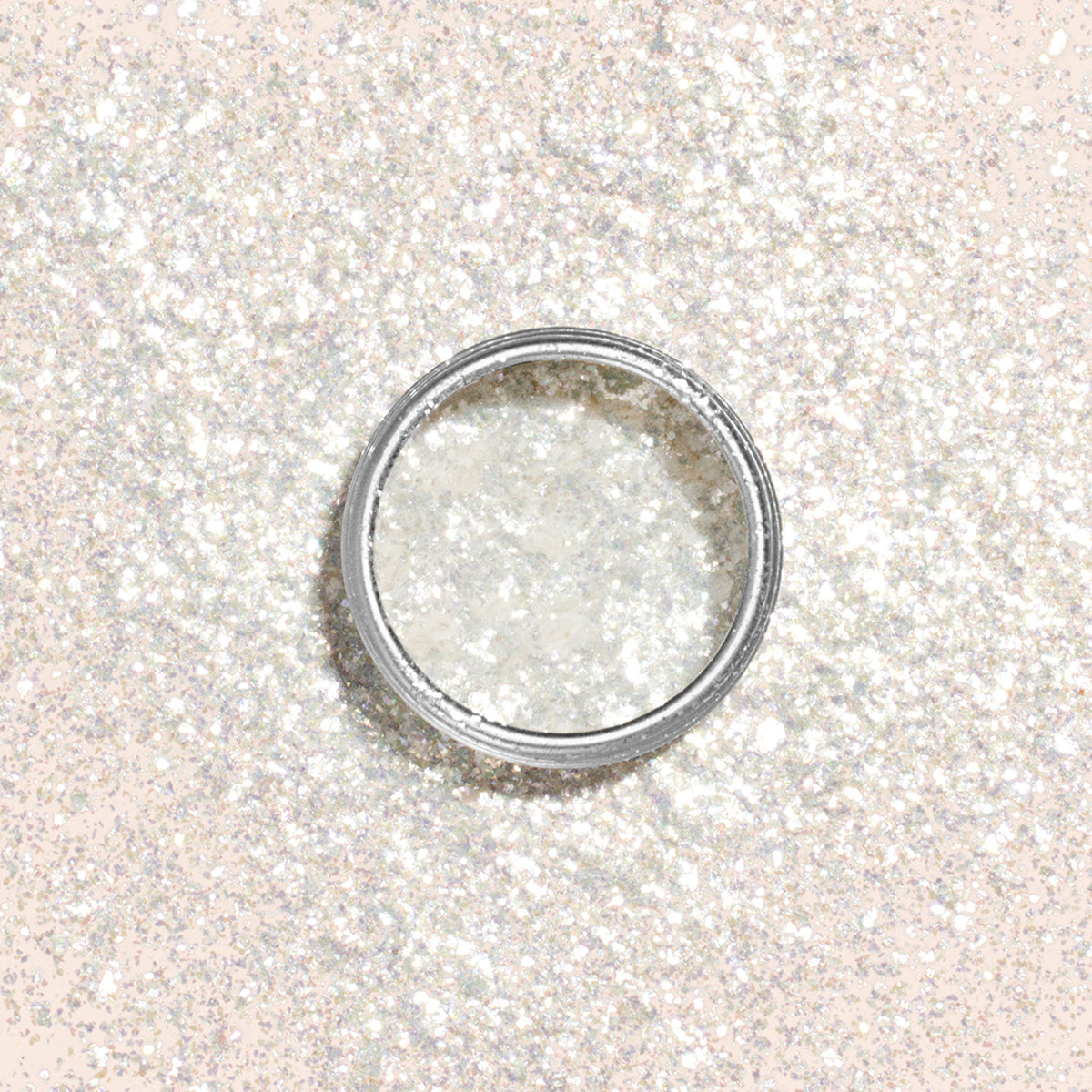 Manucurist Pearlescent Glitter Flakes, a fine white glitter in a round open container, sits amid sparkling flakes to create a shimmering effect—perfect for adding brilliance to your next manicure.