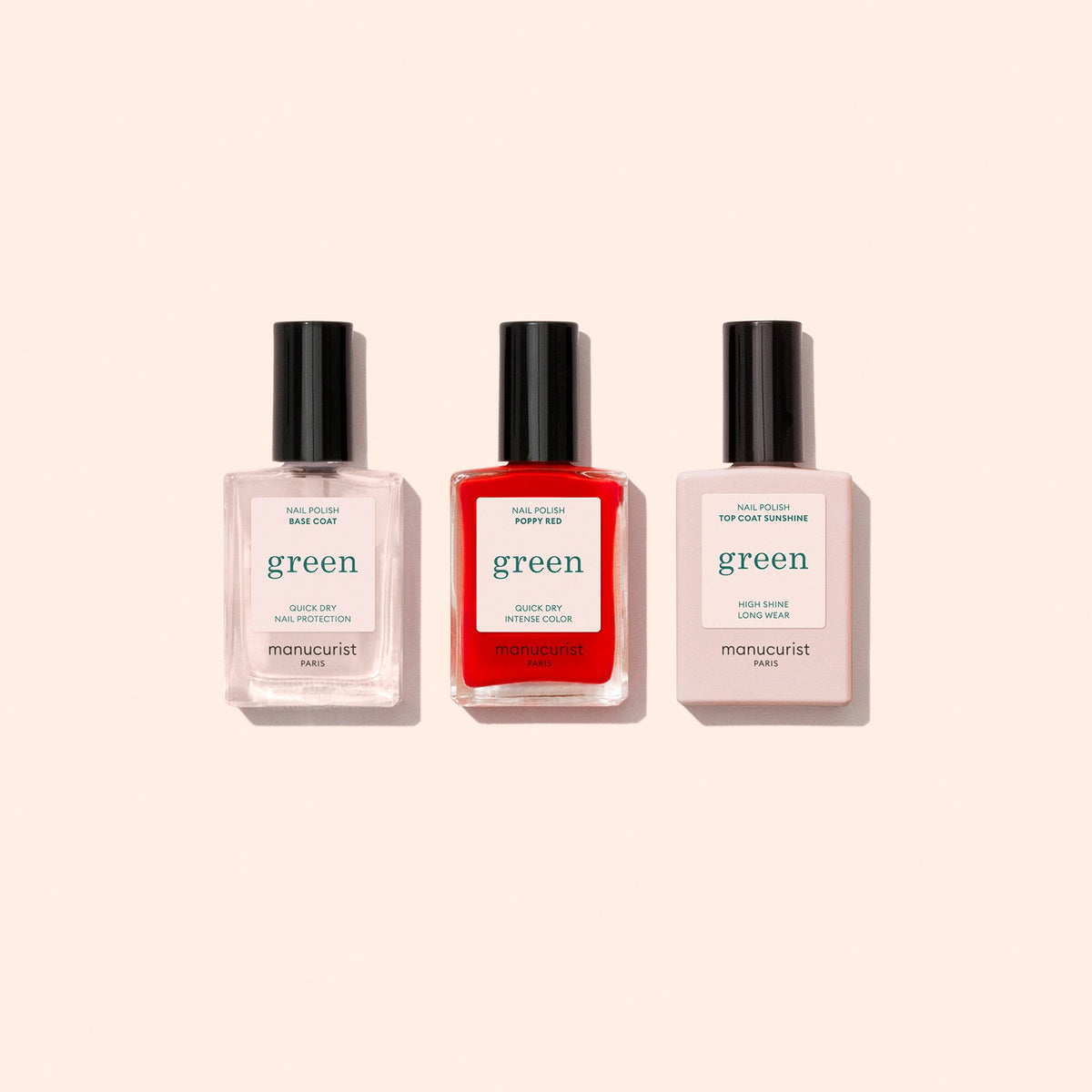 The Manucurist Basic Kit is shown with three bottles side by side on a light beige background. Ideal for gel-effect manicures, the set features a base coat, bright red polish, and top coat—all with sleek black caps.