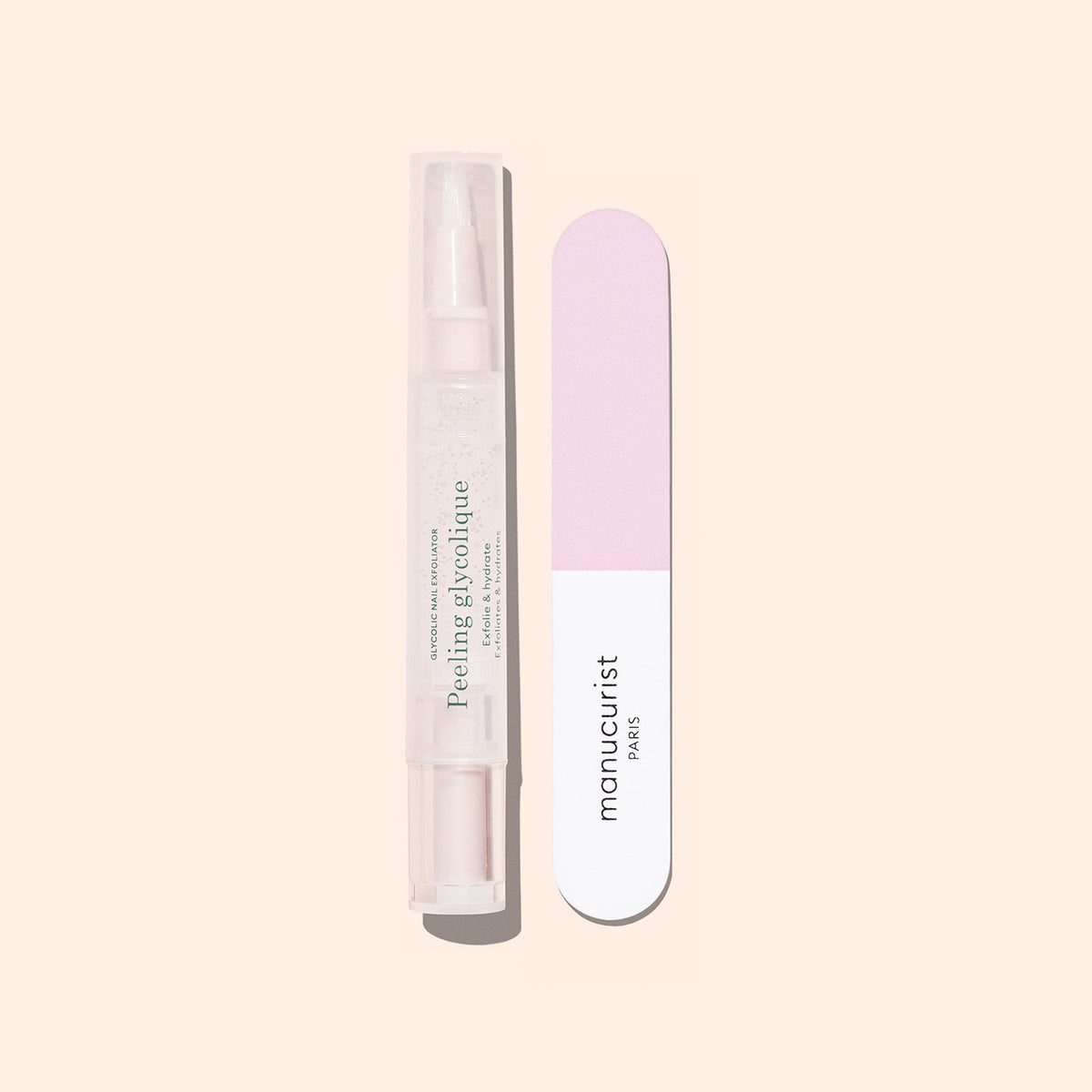 Le Duo Glossy Booster de Manucurist — composé d’un exfoliant doux pour les ongles et d’une lime à ongles rose et blanche — est présenté debout sur un fond beige clair, idéal pour obtenir des ongles brillants.