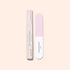 Le Duo Glossy Booster de Manucurist — composé d’un exfoliant doux pour les ongles et d’une lime à ongles rose et blanche — est présenté debout sur un fond beige clair, idéal pour obtenir des ongles brillants.