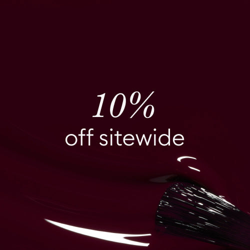 White text on a dark burgundy background reads 10% off sitewide. A black-tipped brush with white bristles appears in the lower right corner, partially covered in glossy burgundy liquid.