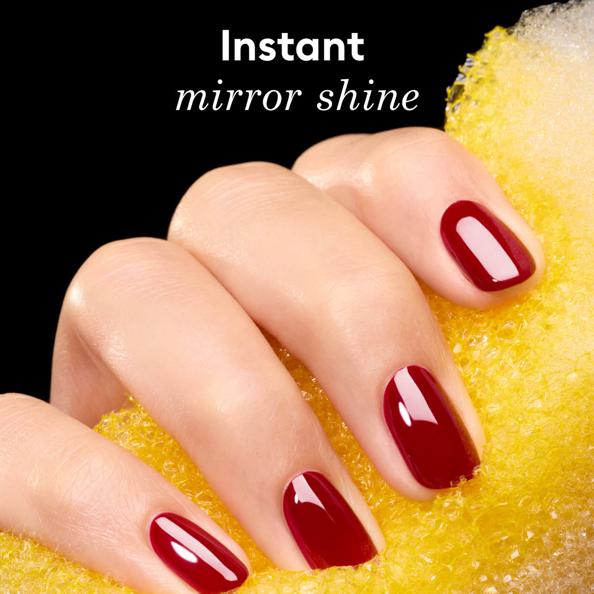 A hand with glossy red-painted nails holds a yellow textured sponge against a black background. White text above reads: “Instant mirror shine.”.