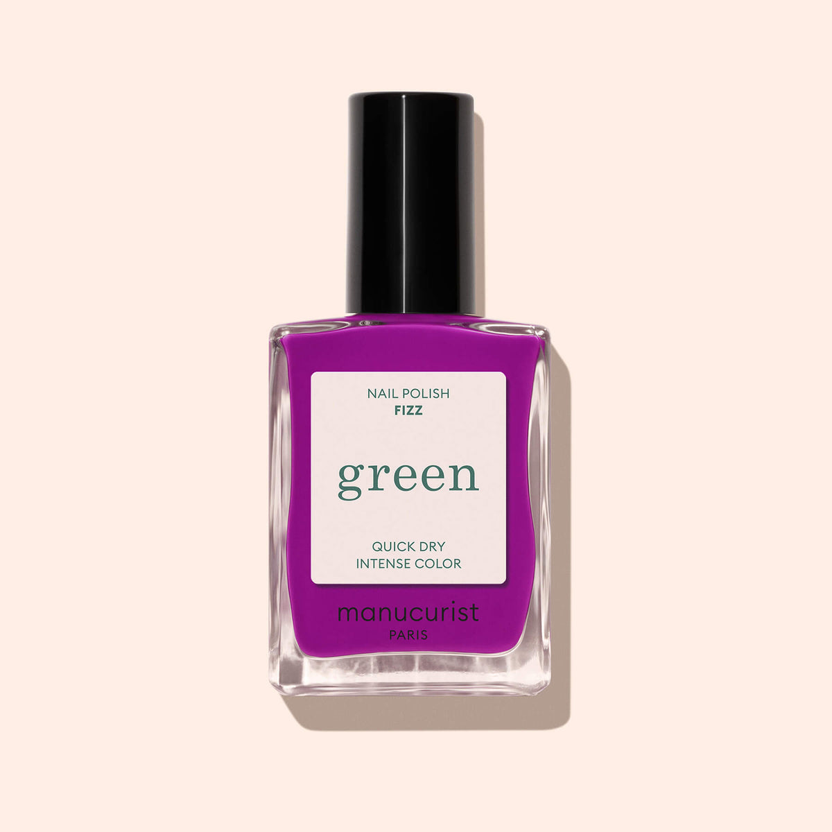 Un flacon de vernis Manucurist Fizz violet vibrant aux reflets magenta, avec une étiquette verte indiquant « Quick Dry Intense Color » sur le devant, présenté sur fond beige clair.