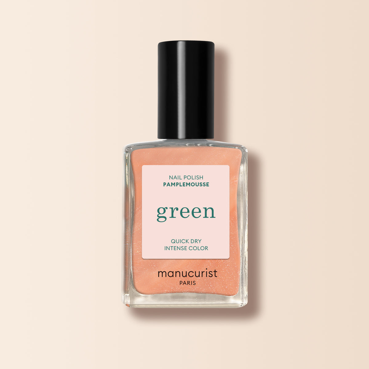 A bottle of Manucurist Pamplemousse orange nail polish in a peachy-orange shade, featuring a black cap and a label that emphasizes its quick-dry and intense color formula.