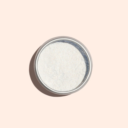 A round metal tin of Manucurist Blue Glazed Powder, a fine white manicure powder, viewed from above on a light beige background.