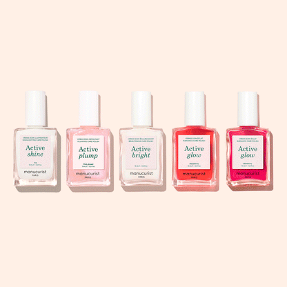 Five bottles from the Manucurist Customizable Active™ 5-pack—each labeled with a different effect, including Active Shine, Active Plump, Active Bright, and two bottles of Active Glow—are arranged in a row on a light beige background. This set is designed to deliver personalized makeup effects for your nails.