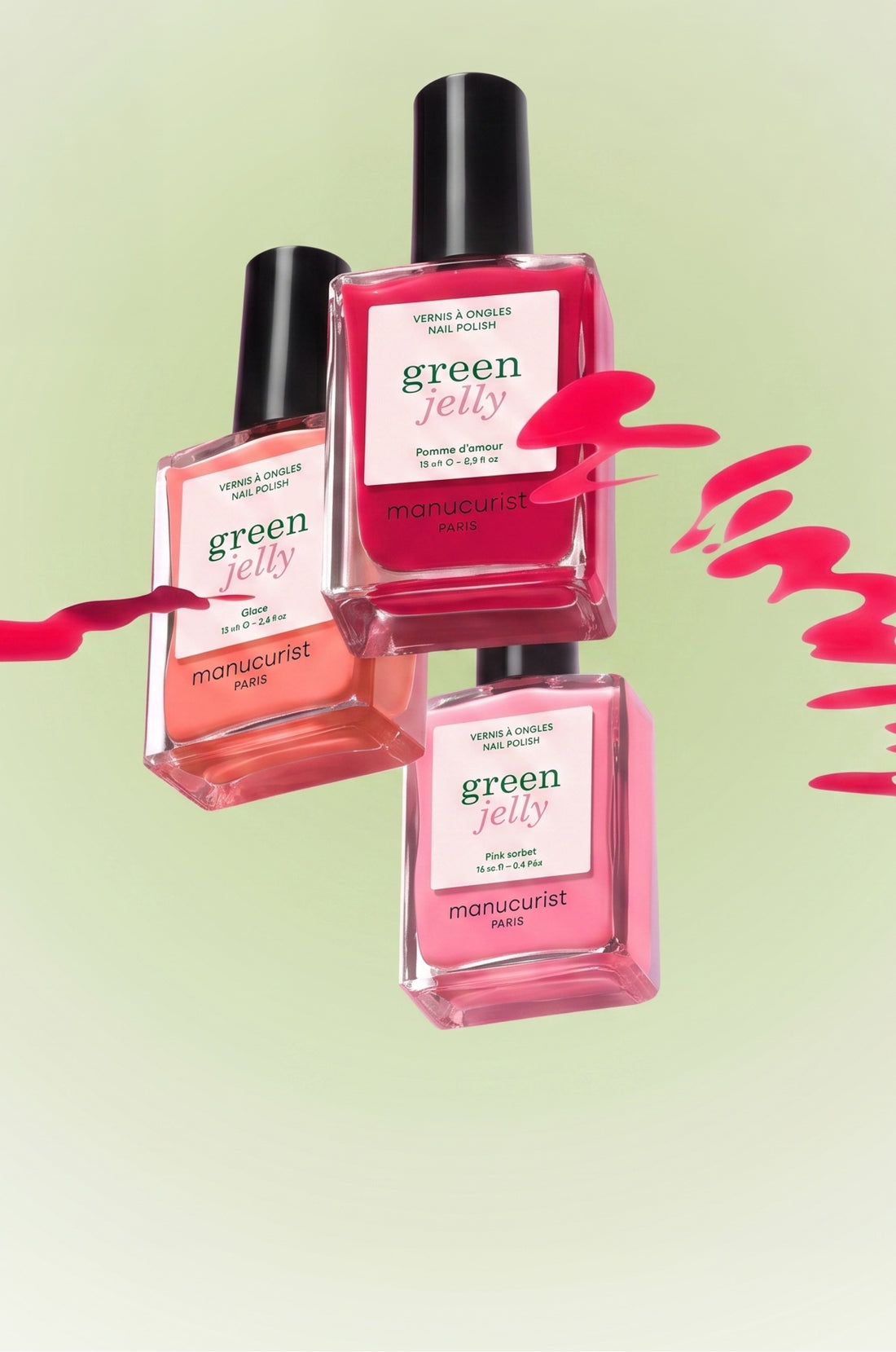Three bottles of Manucurist Paris Green Jelly nail polish in pink and coral shades are floating against a light green background, with pink polish splash accents beside them.