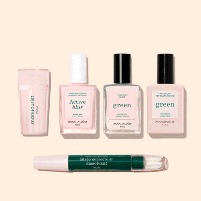 Five manicure products from Manucurist’s French Active™ Kit are shown on a beige background: a pink cylindrical container, a square bottle labeled Active blur, two green-labeled nail polish bottles, and a dual-ended Stylo correcteur pen.
