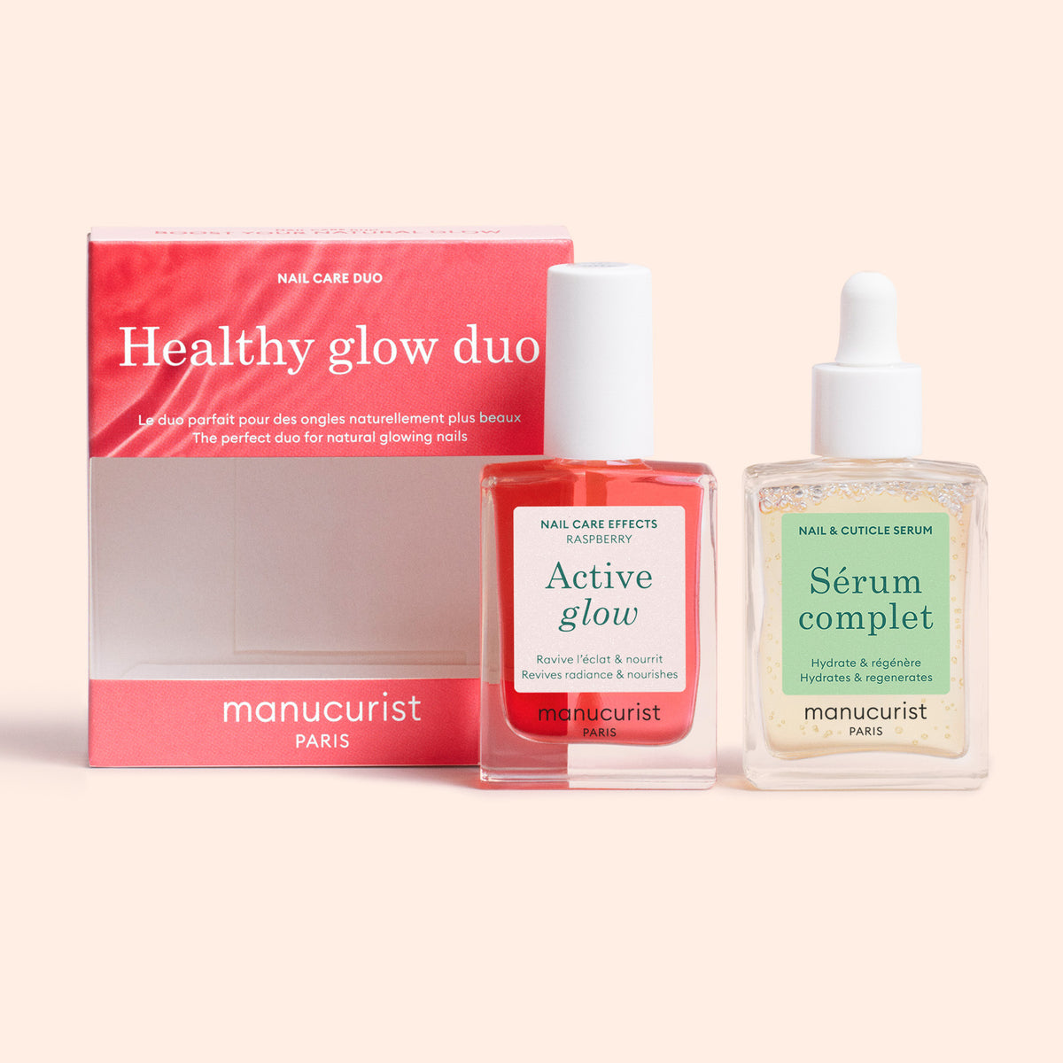 Un coffret rose et blanc étiqueté Healthy Glow Duo par Manucurist est posé à côté de deux flacons Manucurist : un vernis à ongles rouge, Active Glow, et un sérum pour ongles transparent, Sérum Complet.