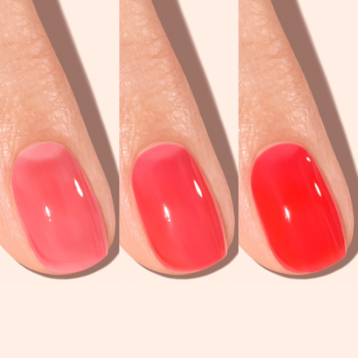 Three fingers with nails painted in different shades of pink and red, arranged side by side from lightest to darkest polish on a light background.