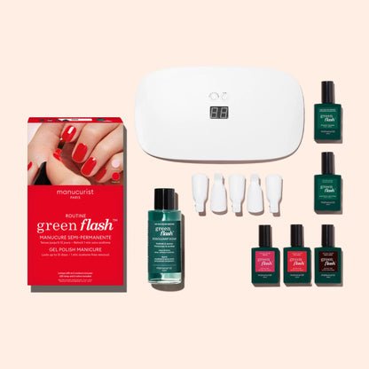 The Manucurist Starter Kit includes a red box, six ultra-glossy green and red gel polishes, remover, four white nail clips, and a white UV LED lamp—all displayed on a light beige background.