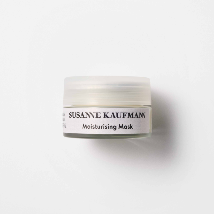 A small, frosted jar with a white lid labeled Susanne Kaufmann Moisturising Mask sits on a white background, casting a soft shadow to the right.