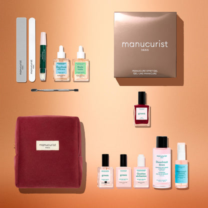 Top-down view of the Manucurist Green™ Discovery Kit Gift Set, featuring nail files, a cuticle tool, two serums, naturally derived red nail polish, wipes, cuticle gel, remover, a top coat for a gel-effect manicure finish, and a chic burgundy pouch—all beautifully arranged on a peach-colored background. The perfect holiday gift set for any beauty enthusiast.
