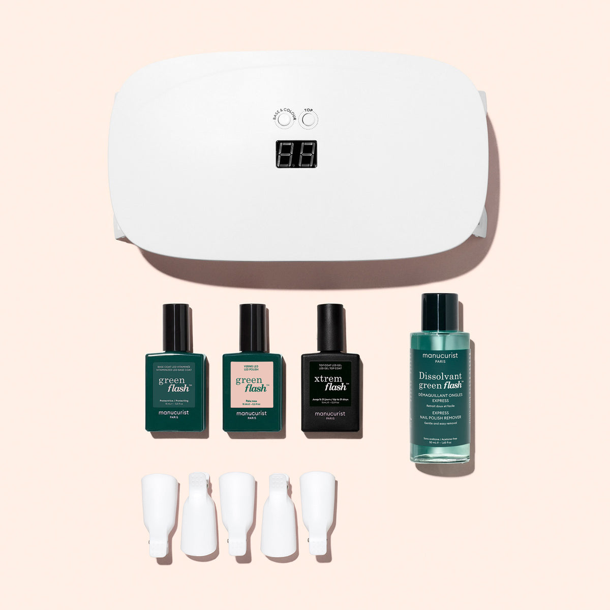 The Manucurist Discovery Kit - Soap Nails LED Gel Polish includes a white LED nail lamp, three small bottles of gel polish, a bottle of remover, and five white finger clips for an ultra-glossy manicure.