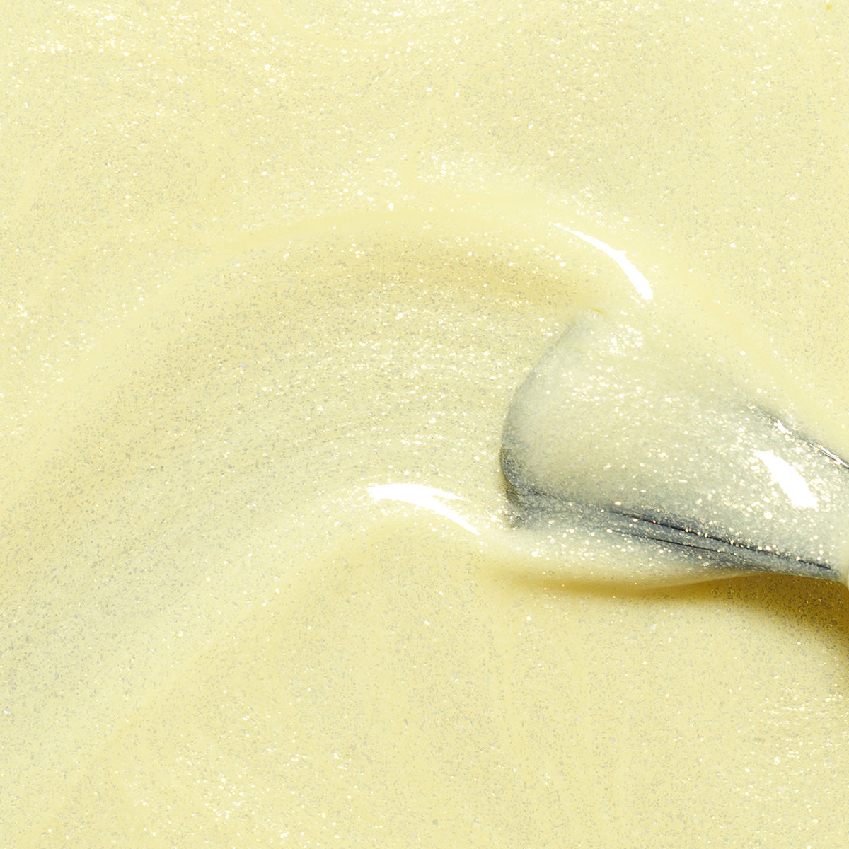 A close-up of a spoon stirring Manucurist&