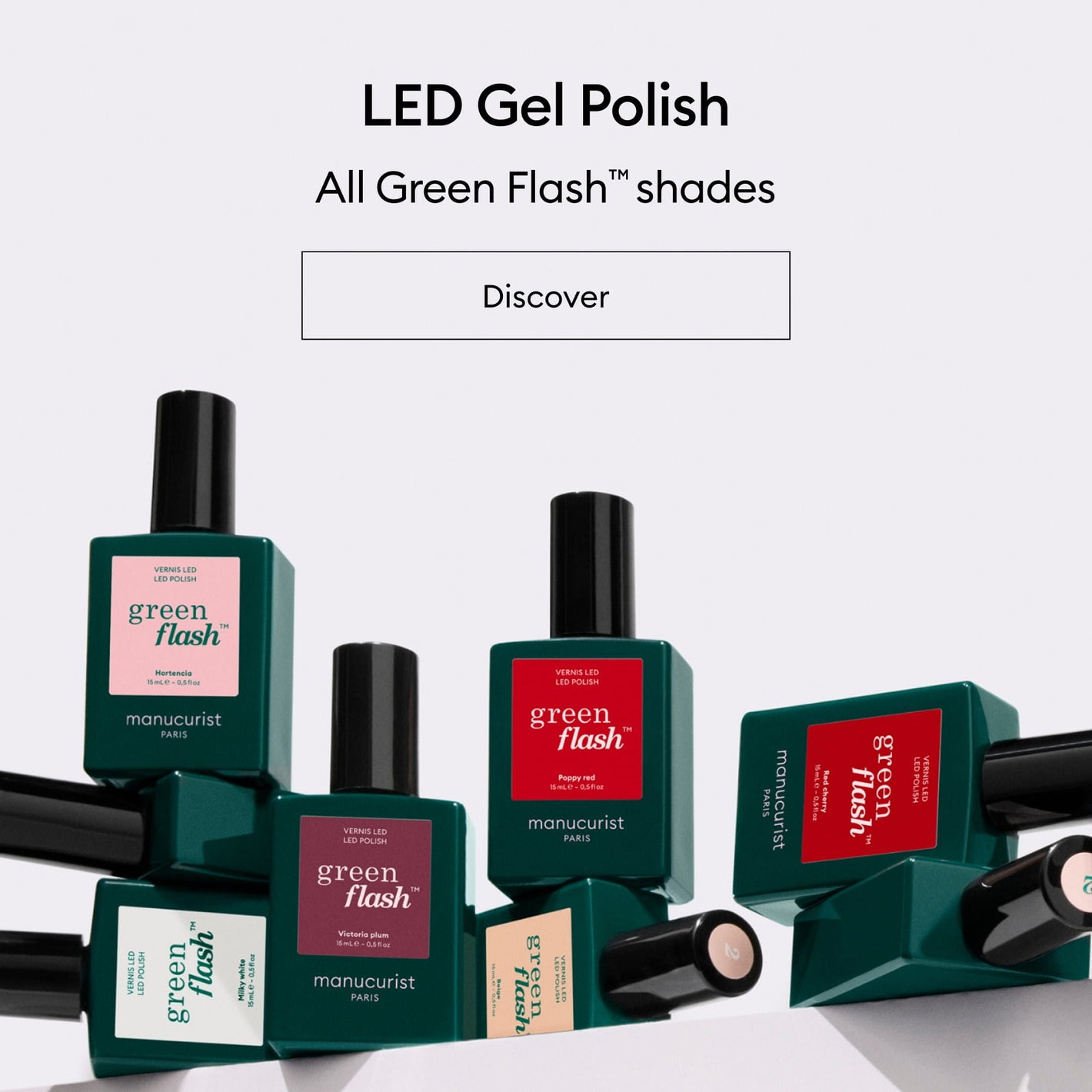 Bottles of Green Flash LED gel polish by Manucurist are displayed on a light surface. Each bottle features a green cap and labels in various colors, showcasing different shades of the polish. Text above promotes the product line.