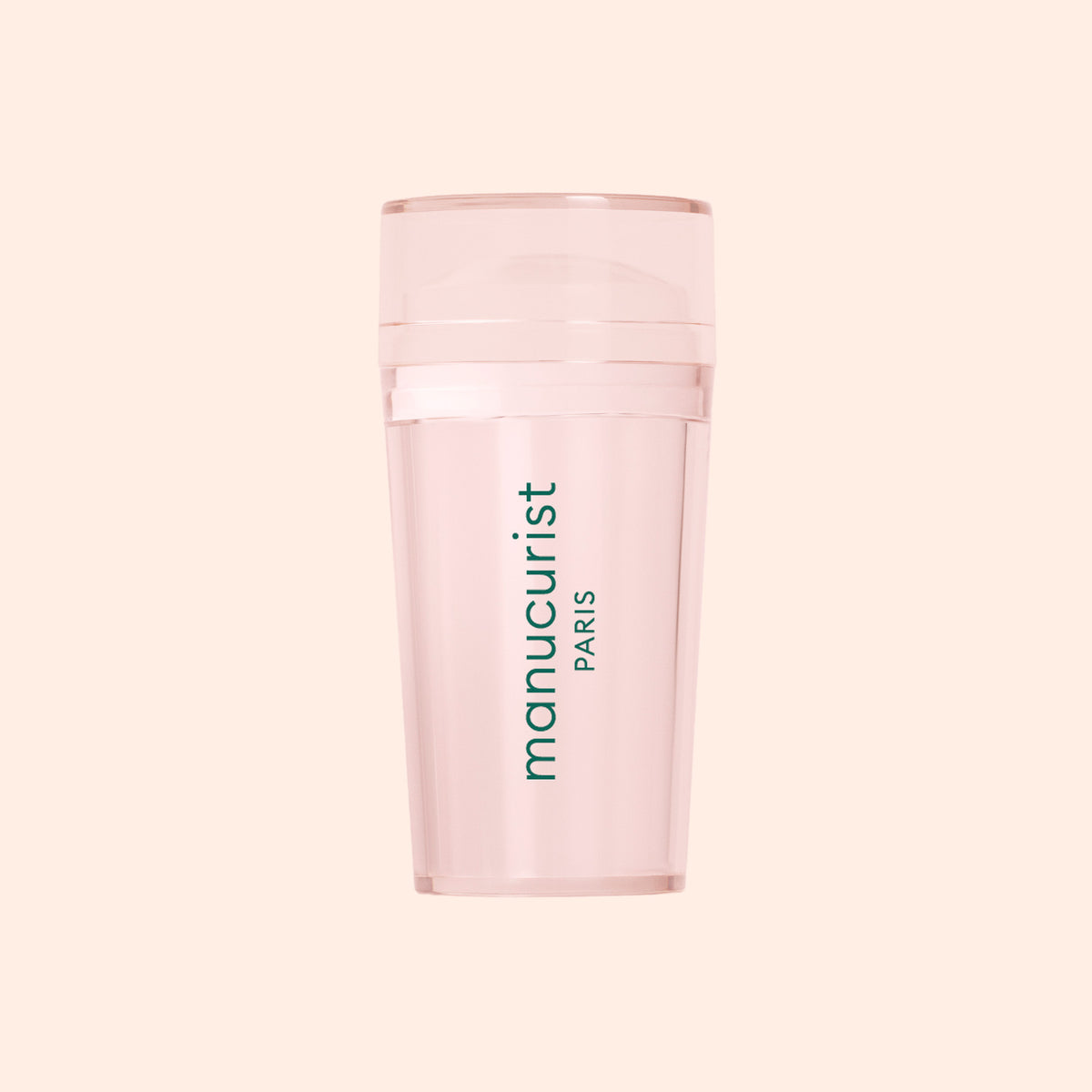 Un tampon Mani rose translucide de Manucurist US, idéal pour les French manucures, avec "manucurist PARIS" imprimé verticalement en vert sur le devant, présenté sur un fond pêche pâle.