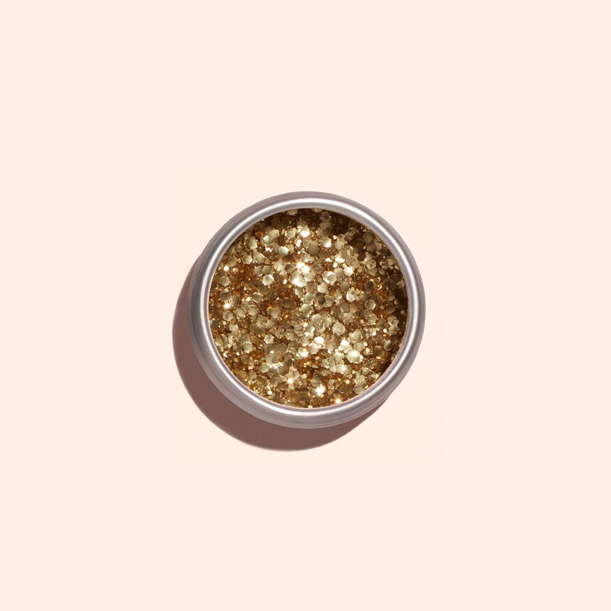 A round tin of Manucurist Gold Biodegradable Glitter rests on a light beige background with a soft shadow—ideal for dazzling nail art or pairing with your favorite gel polish.