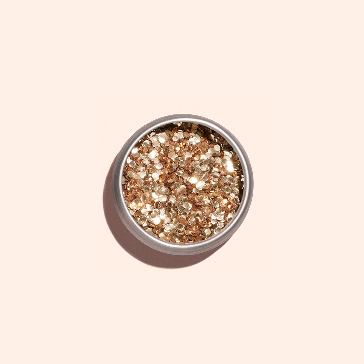 A round container of Manucurist Rose Gold Biodegradable Glitter, perfect for nail art, sits on a light beige background and casts a soft shadow.