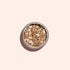 A round container of Manucurist Rose Gold Biodegradable Glitter, perfect for nail art, sits on a light beige background and casts a soft shadow.