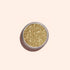 A round Manucurist Golden Chrome Powder container, viewed from above on a pale beige background, ideal for achieving a dazzling chrome finish.