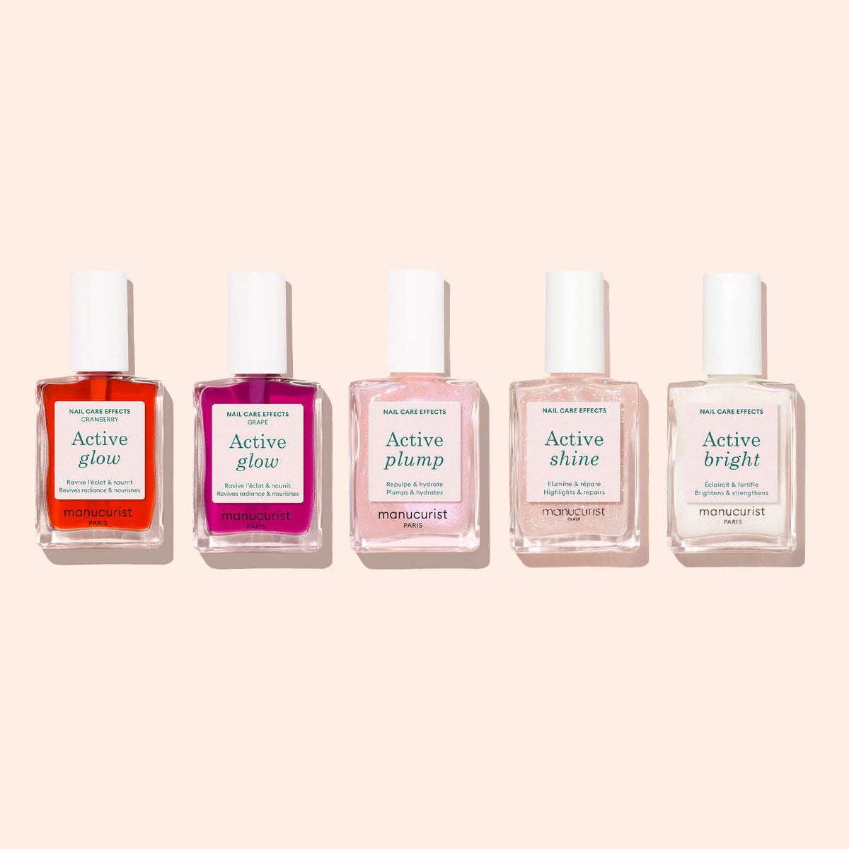 Cinq flacons de vernis soin Manucurist sont disposés sur un fond clair, chacun dévoilant un effet unique : Active Glow Cranberry, Active Plump, Active Shine et Active Bright. Cette collection biosourcée signée Manucurist propose des options allant de la luminosité teintée d&