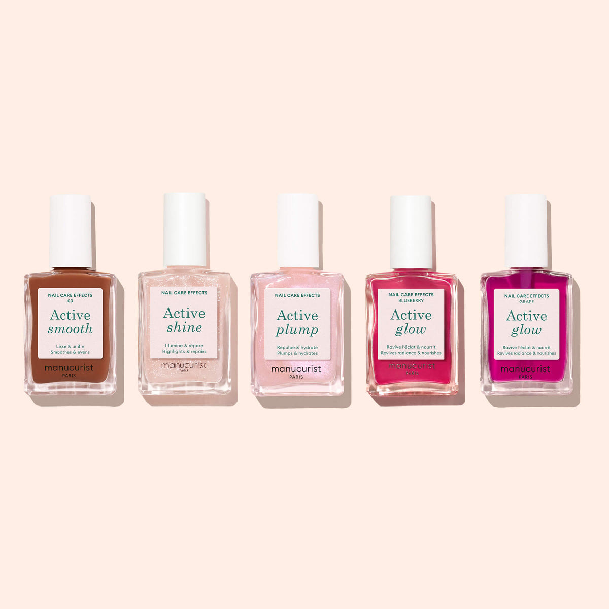 Cinq flacons de soin pour les ongles Manucurist, dont Active Smooth 03, sont disposés en rangée sur un fond beige clair. Chaque flacon est doté d&