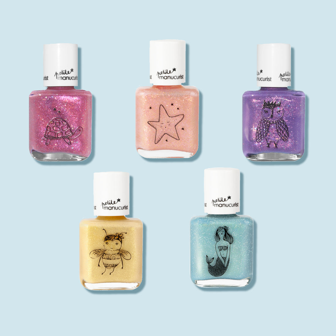 The Manucurist Customizable 5-pack Petite Manucurist set features five kids nail polishes in pastel shades, each bottle adorned with a unique illustration—turtle, starfish, owl, bee, and mermaid—against a light blue background.