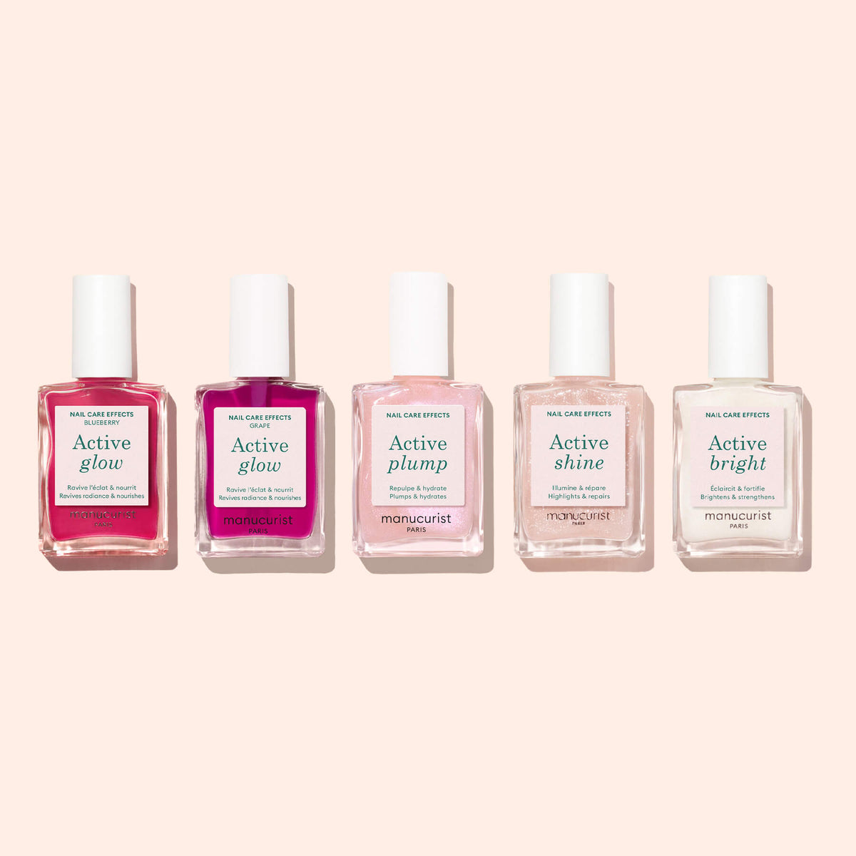 Cinq flacons de soins des ongles Manucurist sont alignés sur un fond rose clair, dont un portant bien en évidence l’étiquette « Active™ Glow Blueberry ». Chaque formule d’origine végétale de la collection promet de sublimer votre routine de soin des ongles en agissant comme un puissant embellisseur d’ongles.