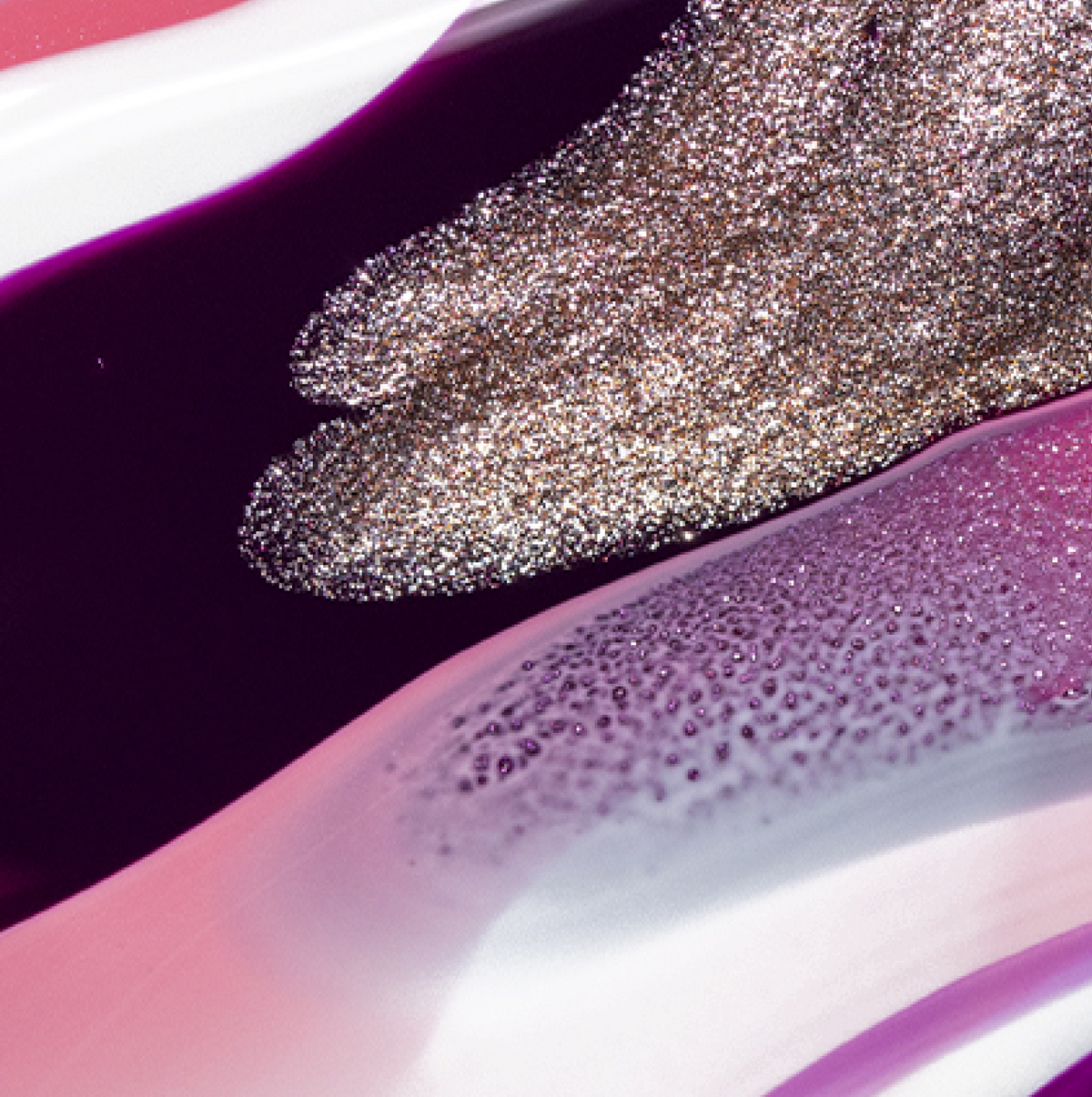 Des volutes de paillettes argentées métallisées et de vernis à ongles brillant violet, rose et blanc créent un motif abstrait et texturé avec des zones chatoyantes et lisses.