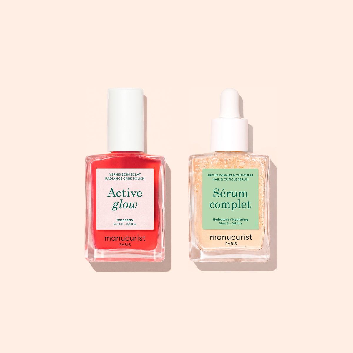 Deux flacons de la Routine Basic de Manucurist - Sensitive Nails — un vernis à ongles Active Glow rouge vif avec un bouchon blanc et un sérum pour cuticules Serum Complet transparent avec compte-gouttes — sont joliment disposés sur un fond pêche clair, offrant le duo parfait pour le soin des ongles et des ongles hydratés.