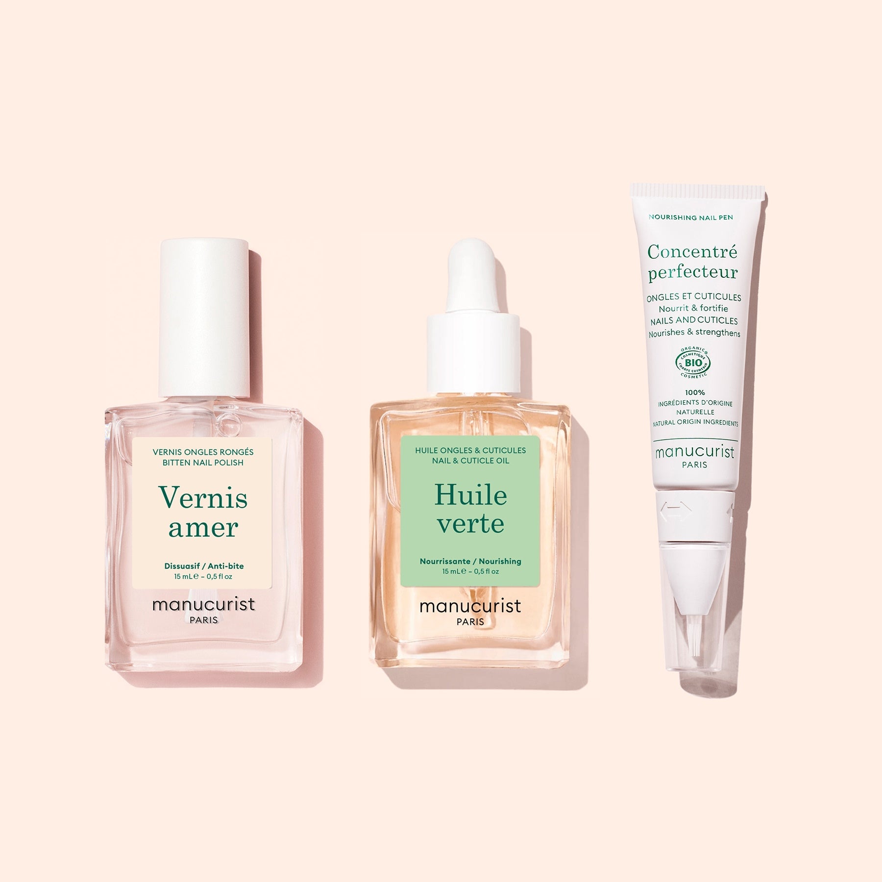 The Manucurist Starter Routine - Bitten Nails set—featuring a pink nail polish, a dropper bottle of nail and cuticle oil, and a nail treatment cream in a white tube on a pale pink background—is designed to support nail regrowth and restore beauty to bitten nails.