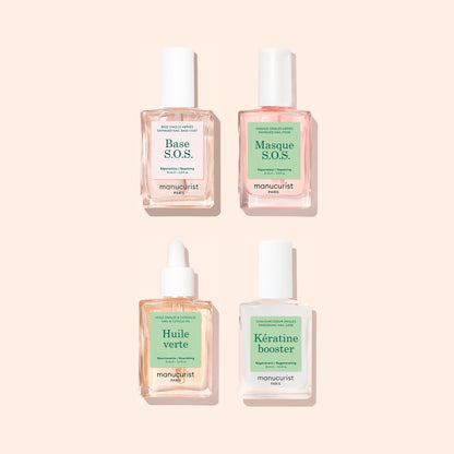 Four manicure treatment bottles from Manucurist’s Basic Routine – Damaged Nails set arranged in a square on a light beige background, perfect for nail repair and strengthening. Labels read: Base S.O.S., Masque S.O.S., Huile verte, and Kératine booster. The clear bottles feature green and pink labels—an ideal set to help restore brittle nails.