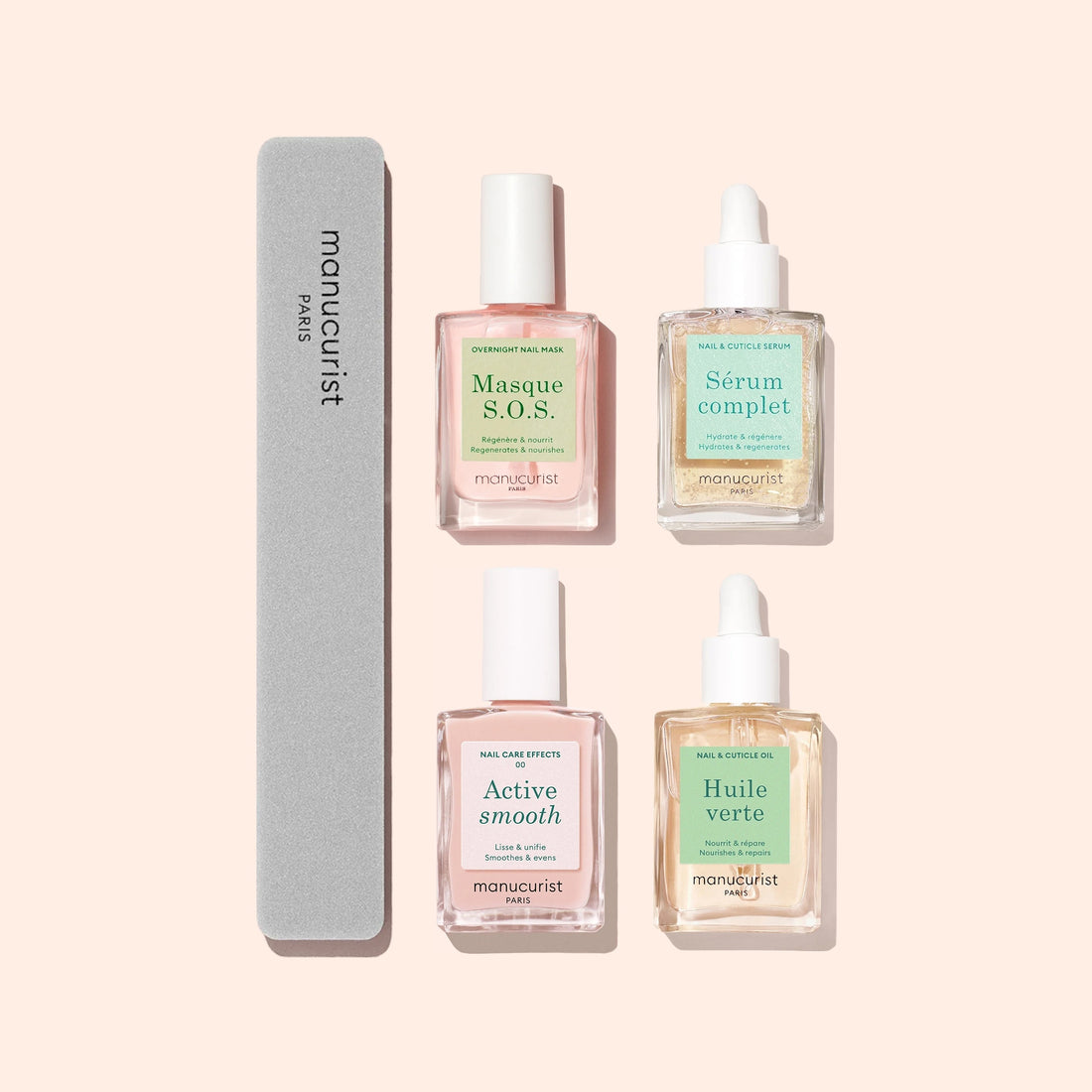 Four manicure products from Manucurist, including a gray nail file and three square bottles labeled Masque S.O.S., Active Smooth, and Huile Verte, plus a dropper bottle labeled Sérum Complet, all on a pale pink background.